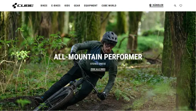  Screenshot der Startseite der Cube-Bikes-Website, zeigt einen Mountainbiker, der durch einen Wald fährt, mit dem Titel 'All-Mountain Performer' und einem CTA-Button zur Anzeige der Bikes. 