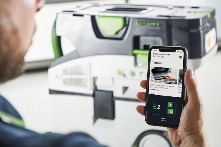 A man watches a tutorial on the Festool website on his smartphone.